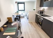 Thumbnail 15 of 23 - A modern kitchen with a dining table and chairs.