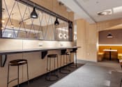 Thumbnail 4 of 36 - A long bar with stools and a mirrored wall above it.