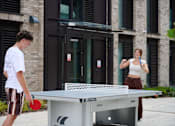 Thumbnail 35 of 36 - A man and a woman playing table tennis on a Cornilleau table.