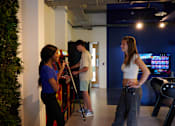 Thumbnail 6 of 36 - Three people playing a video game in a room.