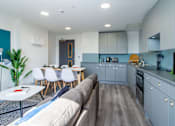 Thumbnail 46 of 51 - A modern kitchen with a dining table and chairs.