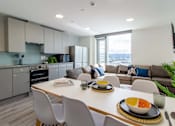 Thumbnail 50 of 51 - A modern kitchen with a dining table set for two.