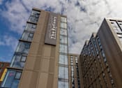 Thumbnail 51 of 51 - The Refinery building is a modern structure with a brown facade and glass windows.