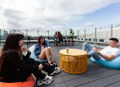 Thumbnail 42 of 51 - A group of people sitting on bean bags on a rooftop.