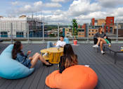Thumbnail 46 of 51 - Four people sitting on bean bags on a wooden deck.