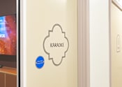 Thumbnail 26 of 56 - A wall with a Karaoke sign and a blue circle with the words "Fire door keep shut".