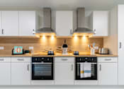Thumbnail 19 of 56 - A modern kitchen with black and white appliances and wooden accents.