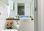 Thumbnail 20 of 56 - A white sink in a bathroom with a towel on the counter.