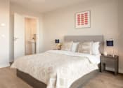 Thumbnail 6 of 11 - a bedroom with a bed and a door to a bathroom