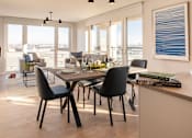 Thumbnail 8 of 11 - a dining room and living room with a table and chairs