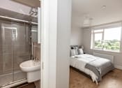 Thumbnail 11 of 11 - a bedroom with a bed and a bathroom with a shower