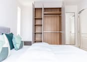 Thumbnail 8 of 11 - a bedroom with a bed and a closet with shelves