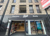 Thumbnail 23 of 23 - the front of a pharmacy store in a brick building