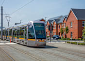 Thumbnail 12 of 22 - a silver and yellow streetcar driving down a street