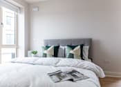 Thumbnail 9 of 11 - a bedroom with a bed with pillows and a magazine on it