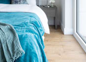 Thumbnail 4 of 10 - a bedroom with a bed with blue and white sheets and pillows