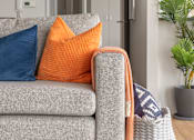 Thumbnail 10 of 10 - a living room with a grey couch with orange and blue pillows