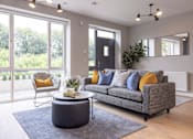 Thumbnail 13 of 15 - a living room with a gray couch and a coffee table