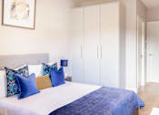 Thumbnail 11 of 15 - a bedroom with a large bed and white closets