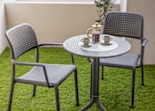 Thumbnail 5 of 15 - a patio table with two chairs and a coffee cup on it