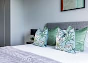 Thumbnail 19 of 23 - a bedroom with a bed with green and white pillows