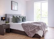 Thumbnail 2 of 23 - a bedroom with a bed and a large window