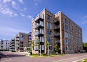 Thumbnail 9 of 23 - a large brick apartment building with balconies on a street