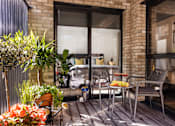 Thumbnail 10 of 23 - a balcony with a chair and a table and a bed