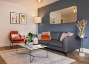 Thumbnail 18 of 23 - a living room with a couch and a coffee table and a mirror
