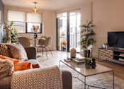 Thumbnail 16 of 23 - a living room with a couch and a table and a television