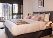 Thumbnail 20 of 23 - a bedroom with a large bed and a balcony