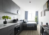 Thumbnail 1 of 8 - a small studio apartment with a bed and a kitchen