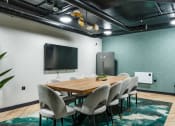 Thumbnail 5 of 8 - a conference room with a table and chairs and a tv on the wall