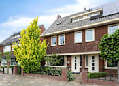 Thumbnail 3 of 7 - the front of a brick house with a yard and a fence