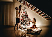 Thumbnail 5 of 14 - a family decorates a christmas tree in their living room