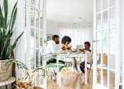 Thumbnail 1 of 14 - group of people sitting around a table eating at a laptop