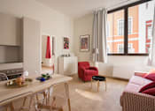 Thumbnail 3 of 14 - a living room with a couch and a dining table
