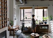Thumbnail 10 of 14 - a woman standing in a living room looking out of a window