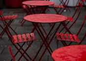 Thumbnail 10 of 20 - a group of red tables and chairs in the rain