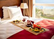 Thumbnail 2 of 20 - a bed with a tray of food and wine on it