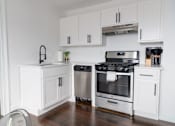 Thumbnail 11 of 14 - a kitchen with white cabinets and stainless steel appliances
