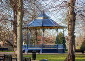 Thumbnail 8 of 12 - a bandstand in a park with trees in the foreground