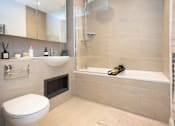 Thumbnail 10 of 23 - A modern bathroom with a white toilet, a sink, and a bathtub.