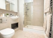 Thumbnail 20 of 23 - A bathroom with a toilet, sink, mirror, and shower.