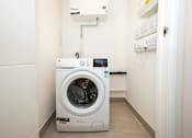 Thumbnail 9 of 23 - A white front loading washing machine with a digital display and a 2 year warranty sticker.