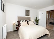 Thumbnail 23 of 23 - A bedroom with a large bed and a radiator on the wall.