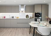 Thumbnail 17 of 23 - A modern kitchen with a dining table set for two.