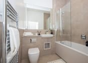 Thumbnail 35 of 37 - A bathroom with a toilet, sink, and shower.