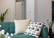 Thumbnail 24 of 37 - A green couch with two pillows on it.