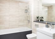 Thumbnail 18 of 25 - A bathroom with a white toilet and a black tub.